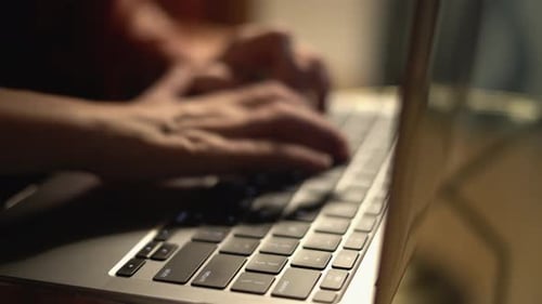 A Closeup View Showcasing Hands Actively Typing on a Contemporary Laptop Keyboard Set Against a