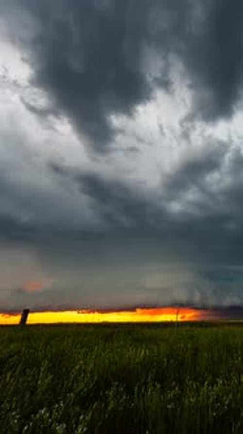 Storm Clouds Rolling Over Green Field at Sunset