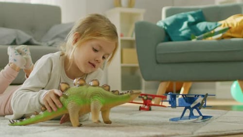 Girl playing with toy dinosaur in living room