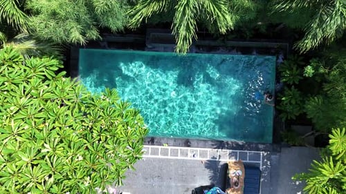 Woman Stands in Refreshing Waters of Pool During Vacation