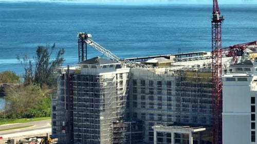 Vista aérea de una grúa de construcción arruinada por el huracán Ian en un edificio de apartamentos alto en el puerto