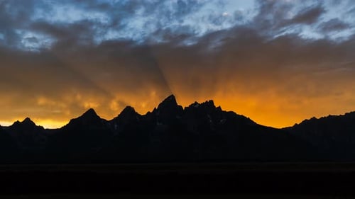 Epischer Berg-Sonnenuntergang im Zeitraffer mit leuchtenden orangen und roten Farben füllen den Himmel