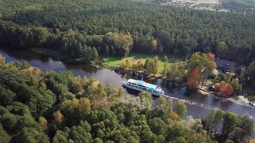 A Passenger Ship Sails Along a Narrow River