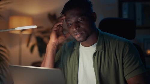 Young Man Working Late at Home on Laptop