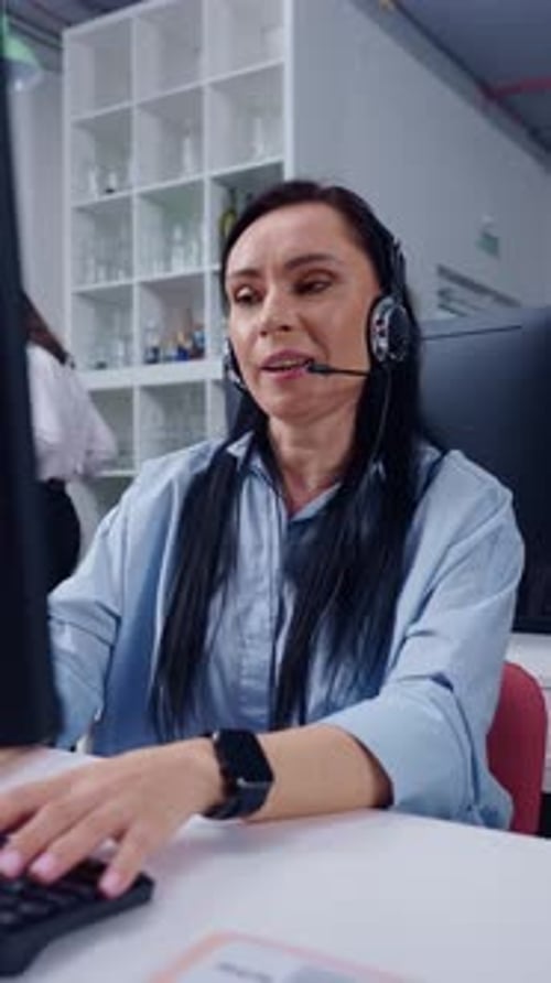 Focused Customer Support Agent Using Headset and Computer While Assisting Clients in Modern Office