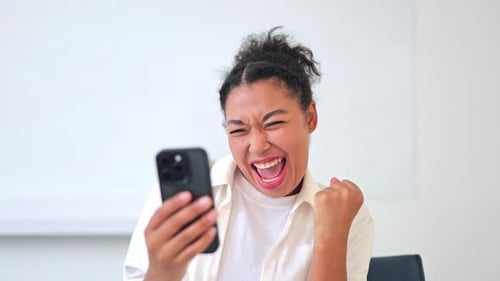 Excited Woman Celebrating Good News on Smartphone