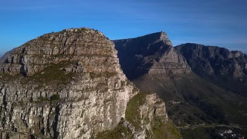 Drone flys behind Lions Head Mountain Peak to reveal Table Mountain in the Background, Aerial, Cape