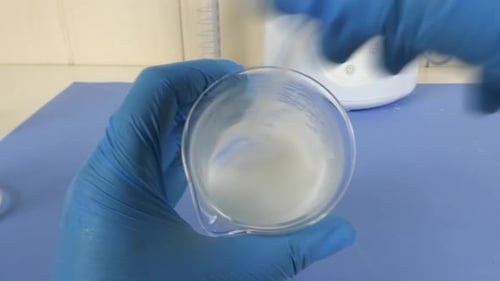 cliché d'une émulsion cosmétique en cours de préparation en laboratoire. Vidéo montrant les gants de l'opérateur