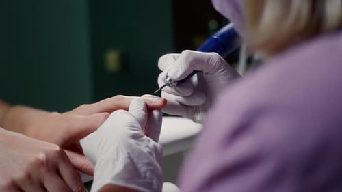 Manicurist Polishes Acryl Gel on Customer Nail with Electric Polisher in Cosmetology Salon Closeup