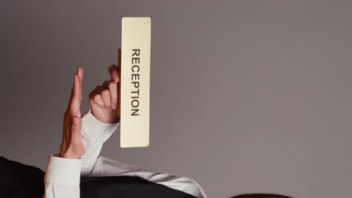 Vertical Video Hotel Concierge Holding Sign to Indicate Direction for Reception Desk
