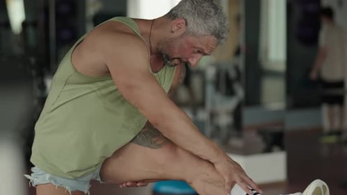 Man Stretching After Workout in the Gym