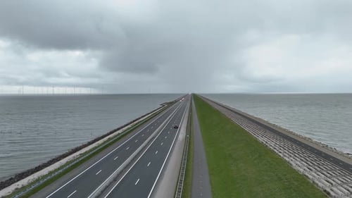 Vertical rise above endless dam fading into cloudy horizon