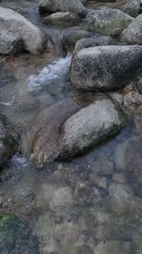 Vertikales Video eines Wasserstroms zwischen Felsen