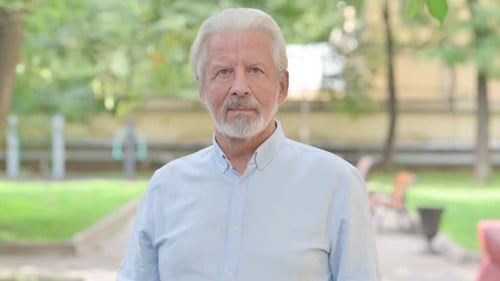 Senior Man Standing in the Park, Looking at Camera