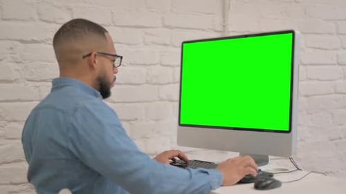 African Man Working on Desktop with Green Screen