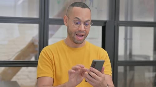 Man Celebrates Success on Smartphone