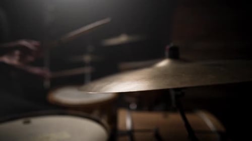 Slow motion cinematic clip of a drummer playing drums with the one cymbal close up and in focus bein