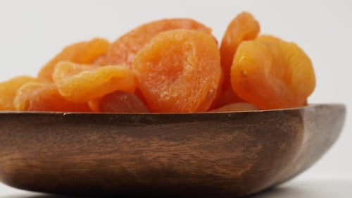 Close Up of Dried Apricots in Wooden Bowl