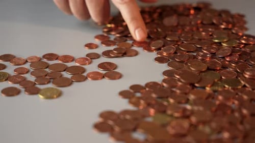 Hand Counting Pile of Bronze and Gold Coins