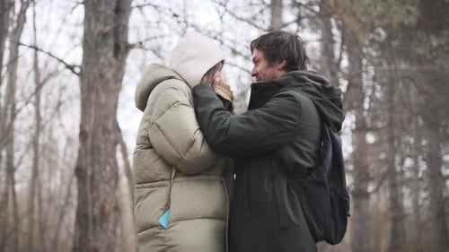 Caring Man Gently Adjusting Woman's Hood Outdoors Romantic Gesture Showing Deep Affection and Care