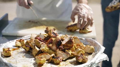 Cutting Grilled Chicken Outdoors for Catering