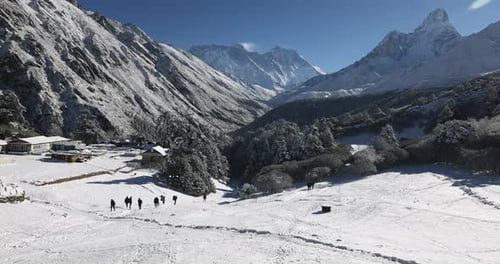 Views outside Tengboche Monastery. People walking in the early morning snow, Nepal.