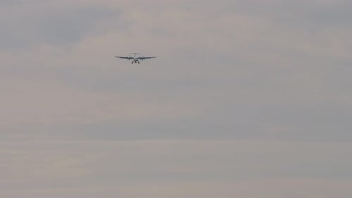 Propeller Plane Flying in a Cloudy Sky
