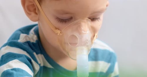 Child Using Nebulizer Mask for Respiratory Treatment