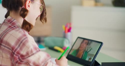 Student in Virtual Class Writing in Notebook