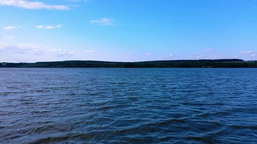 Tagsüber raue Oberfläche des dunklen Flusses. Drohne, die tief fliegt und dann über dem Wasser steigt.