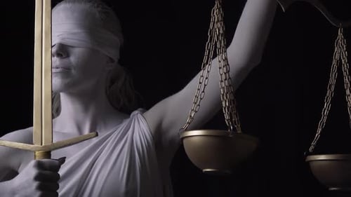 Close Up of Themis Holding Up the Golden Scales and a Sword