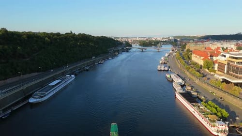 Cinematic Aerial View of Vltava River with Boats and Bright Riverside in Prague Czech Republic
