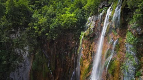 Ein hoher Wasserfall fließt den Felsen hinunter. Gebirgsbäche fließen mit klarem Quellwasser.