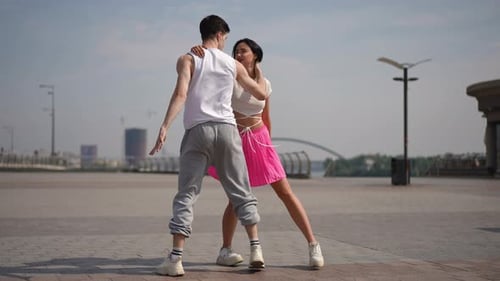 Slow Motion A Young Couple Hones His Skills a Street Dance on a Sunny Summer Day in a City Square