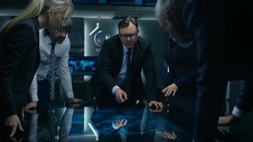 Serious Team Discuss Strategy Around Table in Dark Room