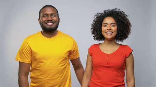 Happy african american couple embracing in a joyful studio portrait