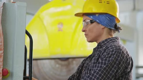 Female Plant Worker Operating Industrial Machine