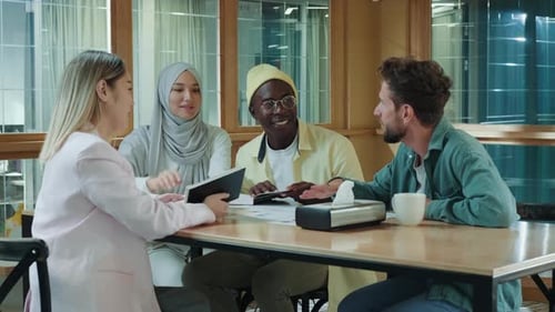 Multiethnic Business Team of Coworkers Discussing a Project While Sitting at the Bar During Lunch