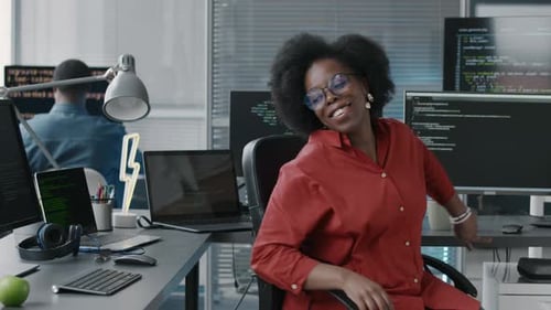 Portrait of Cheerful Black Woman Spinning on Chair in Office