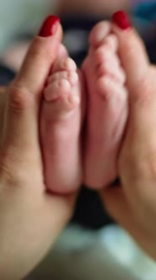Newborn baby fingers. Close up view of baby feet. Vertical video