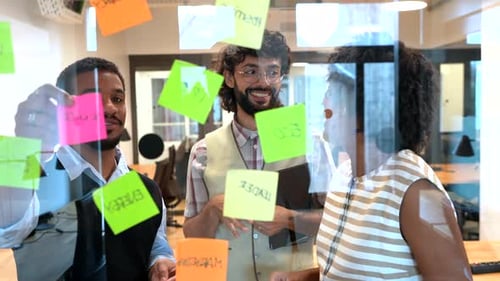 Verschiedene Mitarbeiter beim Brainstorming von Projektideen mit Haftnotizen