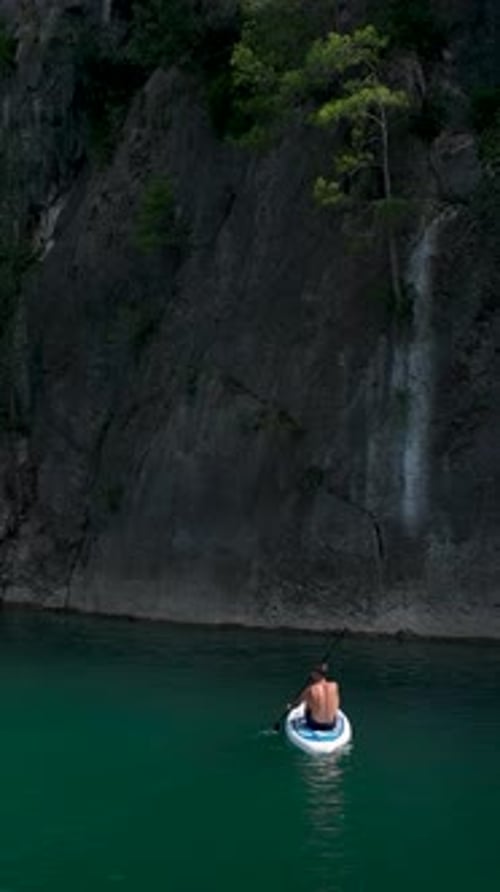 Vertical Video Paddleboarding Through a Canyon With Friends on a Joyful Outdoor Trip