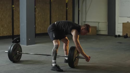 Mann hebt während des abendlichen Trainings Gewichte im Fitnessstudio