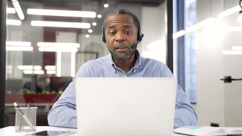 African American male corporate operator who works in customer support speaks on video call using
