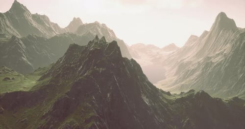 Majestic Mountain Range with Sunlight Illuminating Rocky Peaks and Valleys