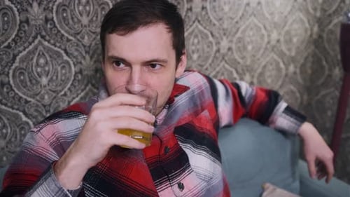 Man Drinking a Beverage on the Couch