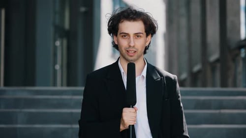 Man Holding Microphone Reporting News in the City
