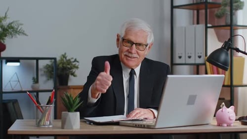 Senior Geschäftsmann hebt Daumen hoch stimmt zu Genehmigen Likes Gute Nachrichten mit Laptop im Home Office