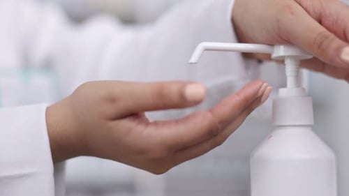 Doctor using hand sanitizer on hands in a hospital, cleaning and sterilize