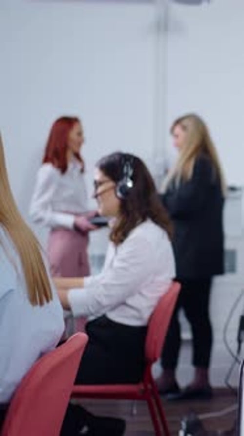 Focused Female Customer Support Representatives Wearing Headsets and Working on Computers in a